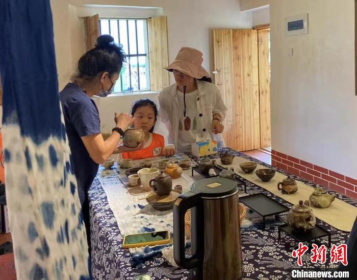 圖為：游客正在咨詢臺(tái)灣柴燒作品?！∪~秋云 攝