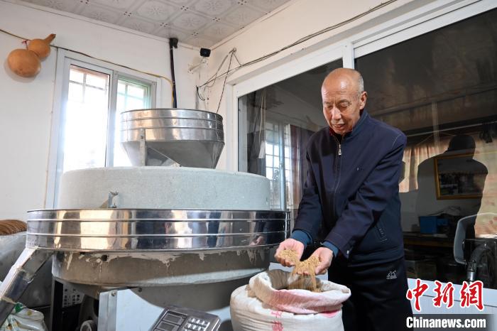 李家莊村民谷文朝重拾父輩的手藝，做起石磨面粉的營生?！〉杂鸺?攝