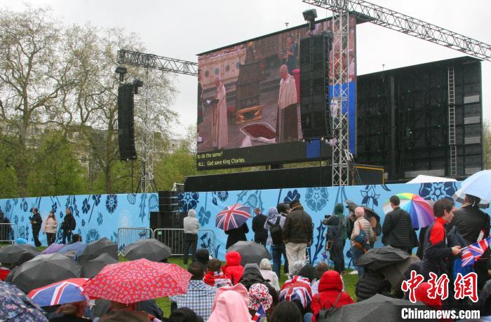 當(dāng)?shù)貢r間5月6日，英國國王查爾斯三世的加冕儀式舉行。民眾雨中觀看儀式。　歐陽開宇 攝