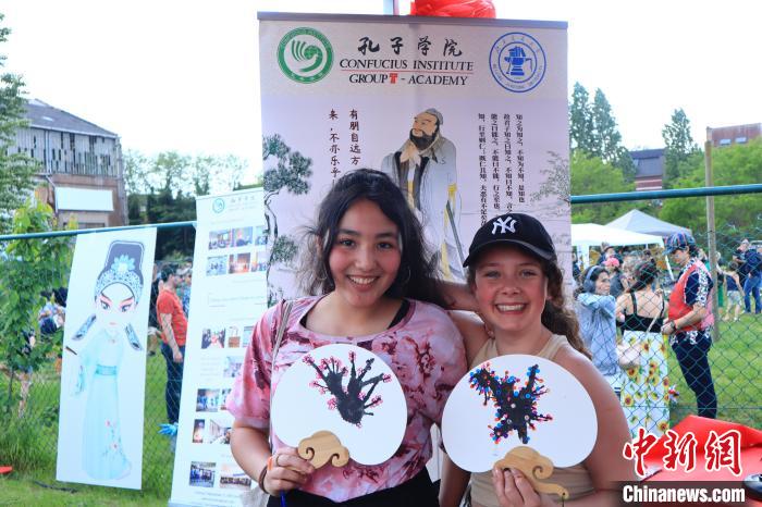 孩子們展示自己的吹墨畫團扇作品?！◆斻肟鬃訉W院供圖