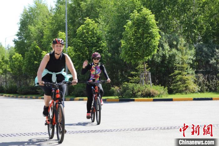 亞信副秘書長遲方(右一)與聯(lián)合國駐哈協(xié)調(diào)員在騎行活動中?！喰琶貢幑﹫D