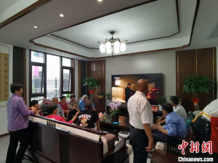 親友們集中在費俊龍家中觀看返程的視頻?！＄娚?攝