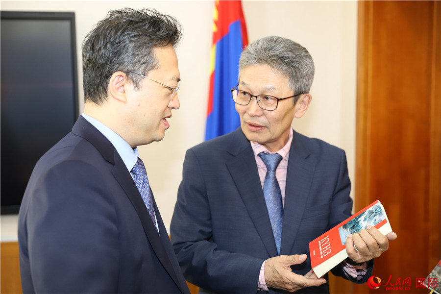 其米德策耶（右一）向李峙介紹翻譯成果。人民網(wǎng)記者 霍文攝