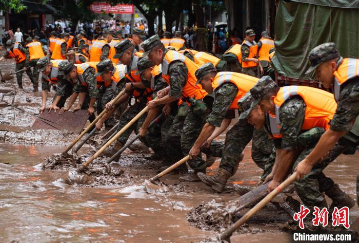 7月4日，萬州區(qū)五橋街道，武警官兵清理街道上的淤泥。　冉孟軍 攝