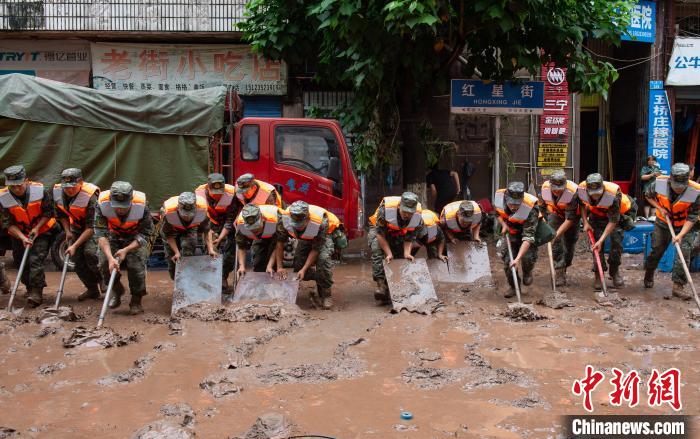 7月4日，萬州區(qū)五橋街道，武警官兵清理街道上的淤泥。　冉孟軍 攝