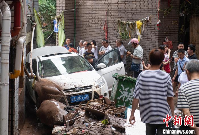 7月4日，萬州區(qū)五橋街道，居民救援受困的私家車。　冉孟軍 攝