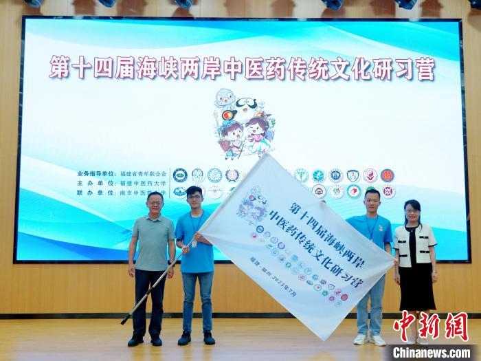 共青團福建省委副書記吳雪(右一)、福建中醫(yī)藥大學黨委副書記林羽(左一)為兩岸學生代表頒授營旗。　許燁婷 攝