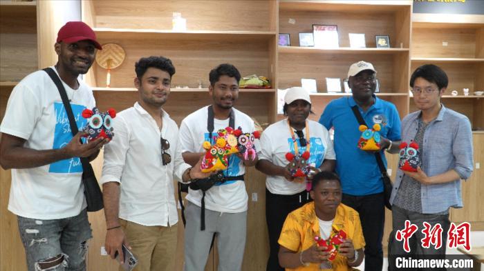 圖為國(guó)際青年代表展示親手制作的東營(yíng)非遺黃河口布偶 ?！↓R魯 攝