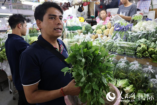 7月19日，泰國曼谷藍象餐廳員工向參加活動的多國代表介紹如何挑選新鮮蔬菜。 人民網(wǎng)記者 張矜若攝