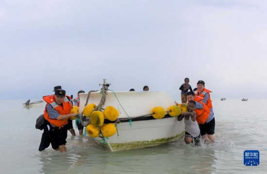 7月21日，中國海軍“和平方舟”號醫(yī)院船醫(yī)護人員涉水登島，前往基里巴斯一診療點。新華社記者 黎云 攝