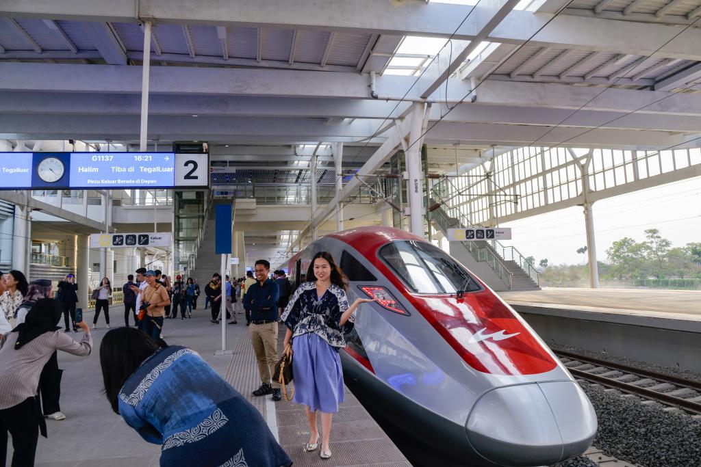 10月17日，在印度尼西亞萬隆德卡魯爾站，乘客在站臺上和雅萬高鐵高速動車組列車合影。