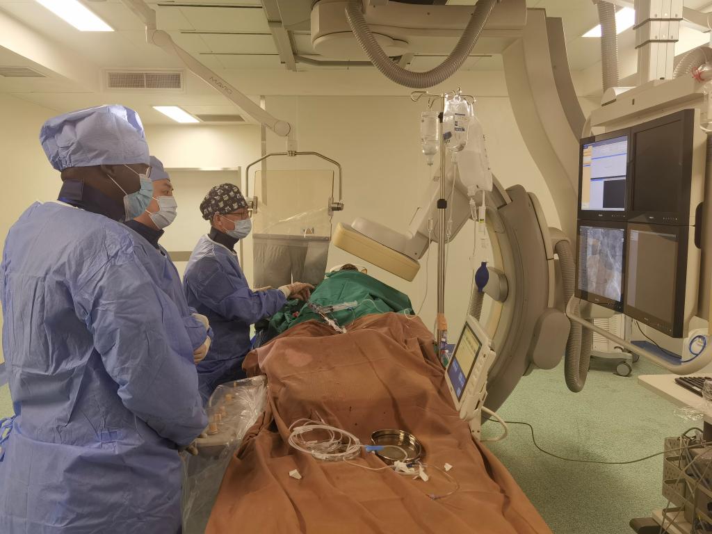 中國(guó)第29批援幾內(nèi)亞醫(yī)療隊(duì)隊(duì)員、首都醫(yī)科大學(xué)附屬北京天壇醫(yī)院心內(nèi)科副主任醫(yī)師王汝朋（右一）正在給患者做手術(shù)。（北京天壇醫(yī)院供圖）