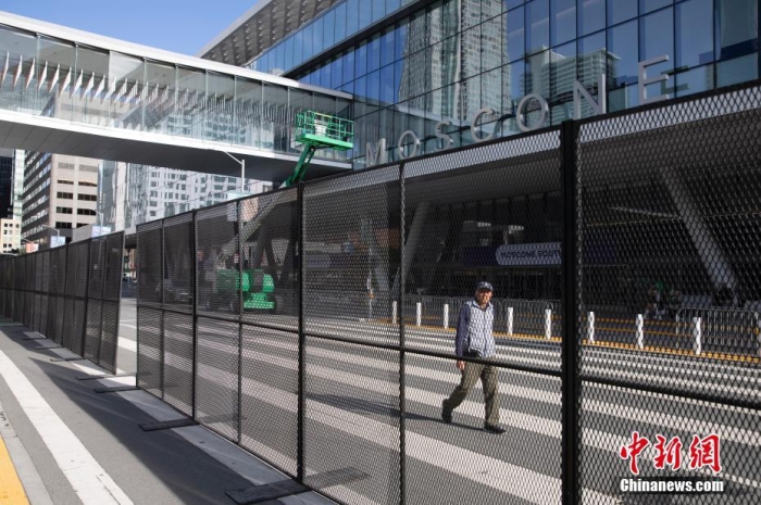 當?shù)貢r間11月10日，一名行人從美國舊金山莫斯康中心周圍的金屬圍欄旁經過。隨著亞太經合組織(APEC)第三十次領導人非正式會議臨近，作為會議場地的莫斯康中心附近出現(xiàn)金屬圍欄，執(zhí)勤警察也大幅增加。<a target='_blank' href='/'><p  align=