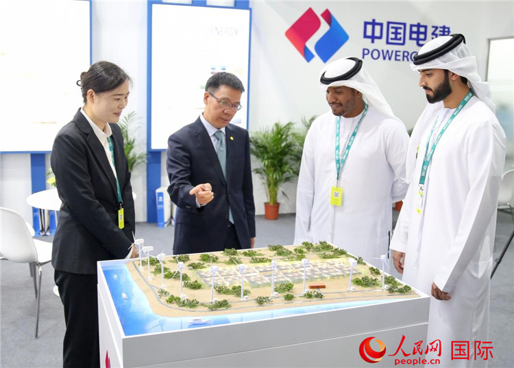 訪客在中國電建展臺參觀風(fēng)電項目沙盤。人民網(wǎng) 塔里克·易卜拉欣攝