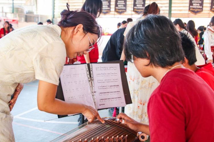 志愿者教師指導(dǎo)學(xué)生彈奏古箏?；顒又鬓k方供圖