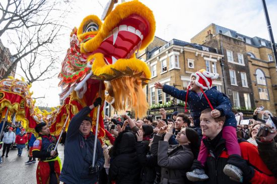 2月11日，人們在英國倫敦的新春巡游活動中觀看舞龍表演。新華社發(fā)（史蒂芬·程攝）