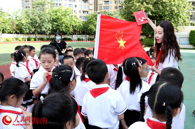 老師向少先隊員展示隊旗。人民網(wǎng) 符武平攝