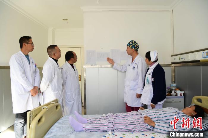 圖為何蔚副主任醫(yī)師(站右二)及團(tuán)隊(duì)術(shù)后對患者的肌肉訓(xùn)練、蛋白飲食等制定了每半日的康復(fù)計(jì)劃。　貢嘎來松 攝