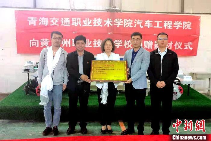 圖為李富香(中)代表學(xué)校為州縣技校捐贈(zèng)器材。(資料圖) 青海省教育廳供圖