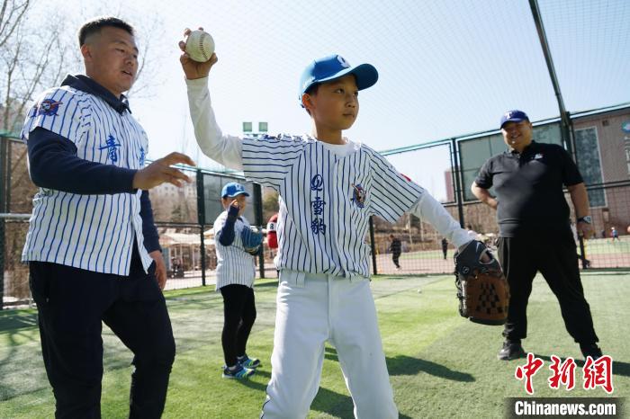 圖為教練指導(dǎo)小棒球手?jǐn)S球技術(shù)?！●R銘言 攝