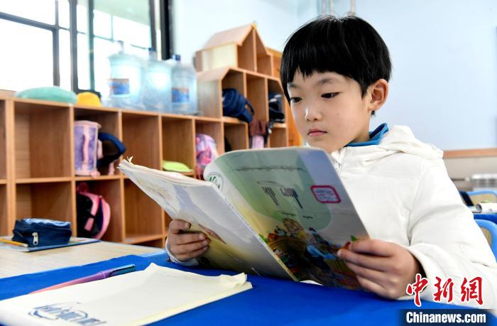 3月14日，西藏拉薩市第一小學(xué)一年級(jí)六班學(xué)生丁增樂吉在閱讀藏語課本?！±盍?攝