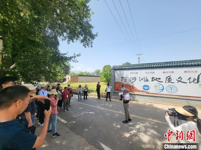 圖為中國(guó)地質(zhì)大學(xué)(北京)教授張緒教介紹村落情況?！『衍?攝