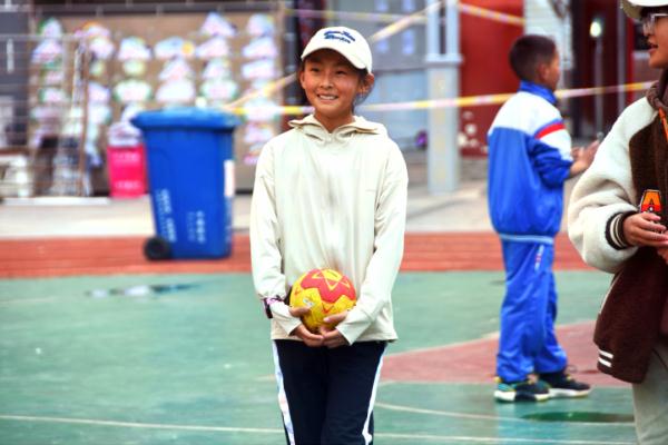 在高原上教孩子們打手球，“慢慢兒來，甭著急！”