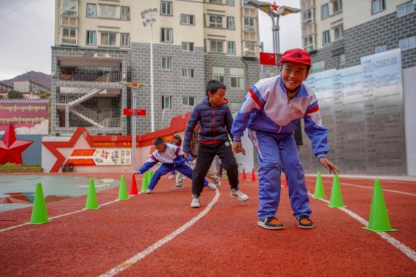 在高原上教孩子們打手球，“慢慢兒來，甭著急！”