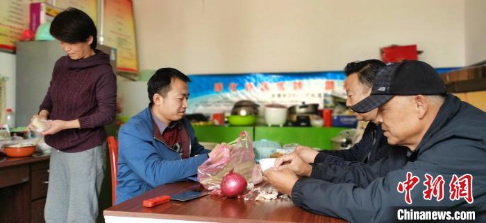 圖為扶貧路上“臨時(shí)一家人”準(zhǔn)備午餐?！∥航ㄜ?攝