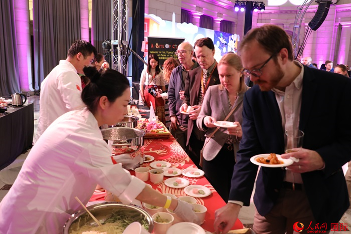 當(dāng)?shù)貢r(shí)間3月7日晚，華盛頓聯(lián)合車站廣場舉行駐美使團(tuán)“使館主廚挑戰(zhàn)賽”。圖為當(dāng)?shù)孛癖娫谥袊古_前體驗(yàn)中國美食。人民網(wǎng)記者 李志偉攝