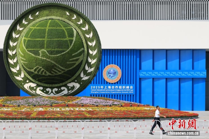 8月31日，天津，一名工作人員從2025年上海合作組織峰會(huì)主會(huì)場(chǎng)外的景觀花壇旁經(jīng)過(guò)。當(dāng)日，2025年上海合作組織峰會(huì)在天津舉行。<a target='_blank' href='/'><p  align=