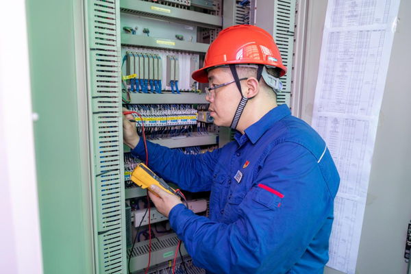 呂曉勇在保護(hù)盤柜前檢查二次回路接線情況。受訪者供圖
