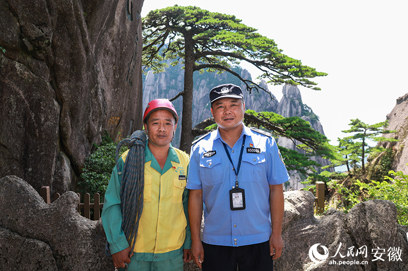 全國道德模范李培生（左）和胡曉春在迎客松前合影。人民網(wǎng)記者 張俊攝