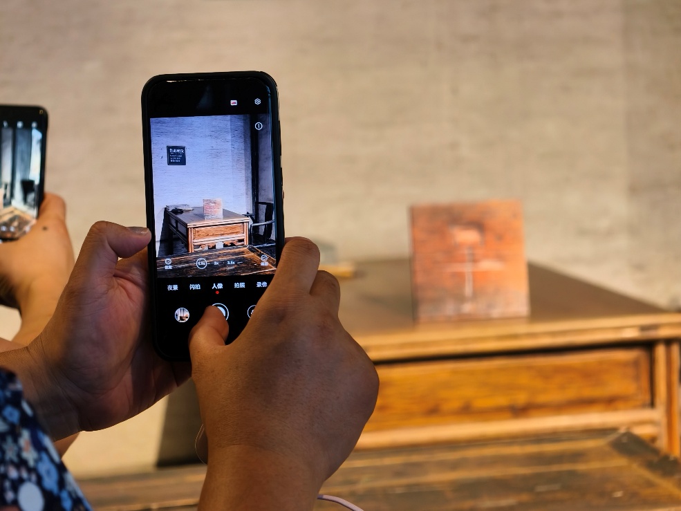 2025年7月15日，暑期研學(xué)團(tuán)小朋友在浙江省紹興市三味書屋拍攝魯迅讀書座位及課桌上的“早”字。受訪者供圖