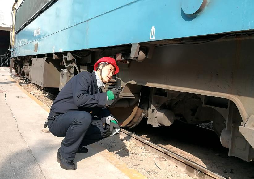 韓文盛全神貫注檢查機(jī)車走行部。