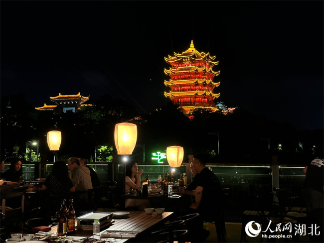 游客登上天臺，賞美景、品美食，沉浸式飽覽黃鶴樓的璀璨夜景。人民網(wǎng) 彭昀迪攝