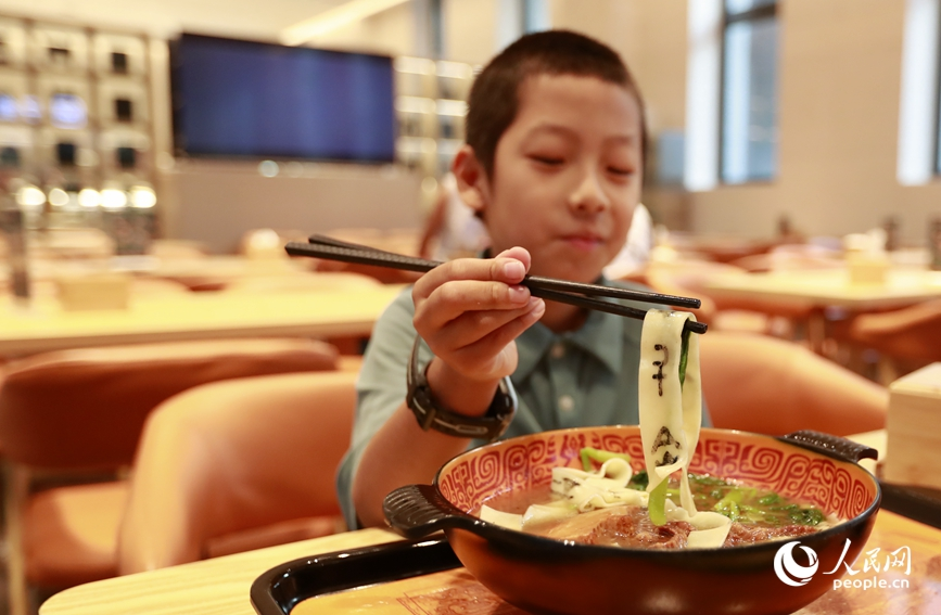 殷墟博物館推出的甲骨文面深受游客喜愛。人民網(wǎng)記者 慎志遠(yuǎn) 攝