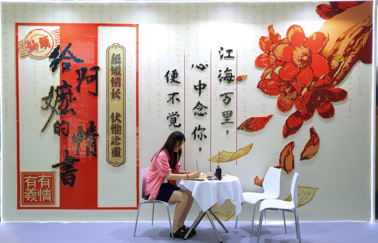 5月21日，與會(huì)者在《給阿嬤的情書》電影主題積木打卡墻前體驗(yàn)寫批。