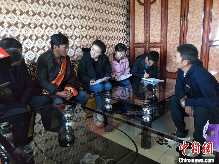 圖為調(diào)查組工作人員正在入戶調(diào)查?！∑钤鲚?攝