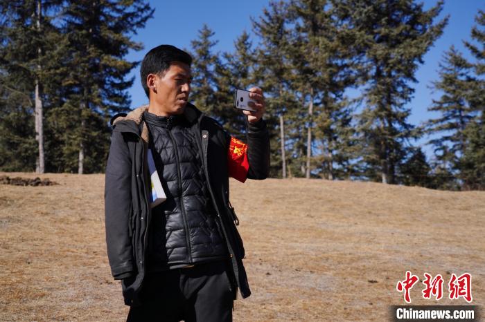 圖為桑杰加進(jìn)行巡查并拍照記錄。　馬銘言 攝