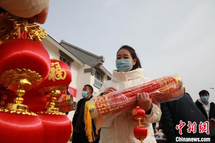 27日，蘭州新區(qū)為舟曲避險搬遷移民送“春節(jié)包”，楊周馬草前往領(lǐng)取，紅色寓意來年的日子紅紅火火。　魏建軍 攝