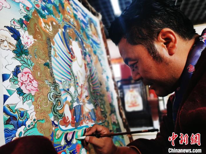 圖為久美尖措創(chuàng)作唐卡?！?zhí)砀?攝