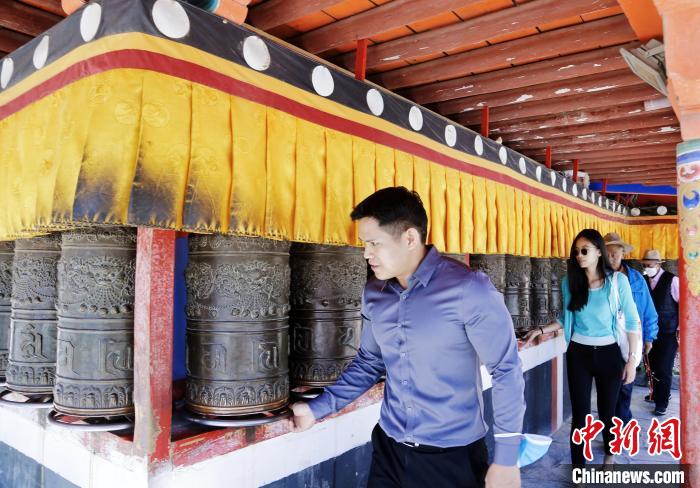 圖為外籍嘉賓體驗藏族傳統(tǒng)轉經筒?！●R銘言 攝