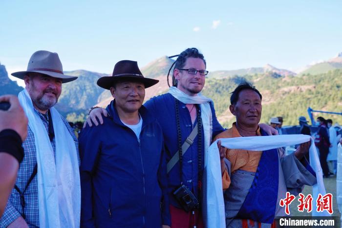 圖為當地民眾與外籍攝影師合影留念?！●R銘言 攝