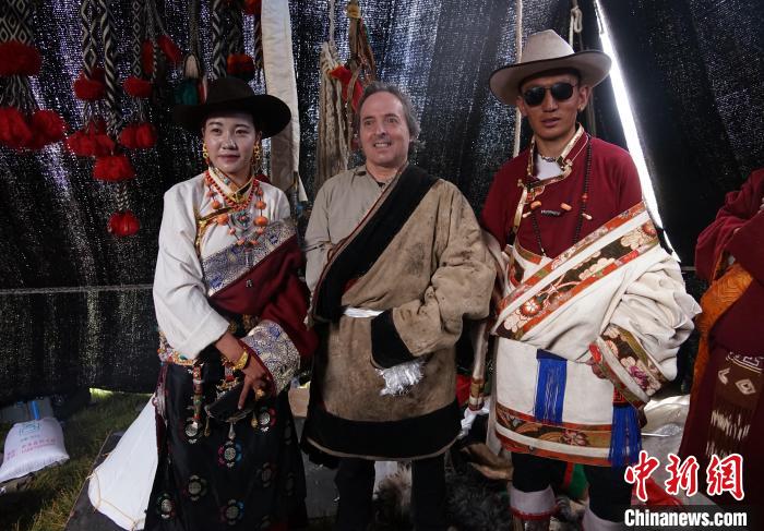 圖為一名外籍?dāng)z影師(中)身穿藏服和藏族民眾合影留念?！●R銘言 攝