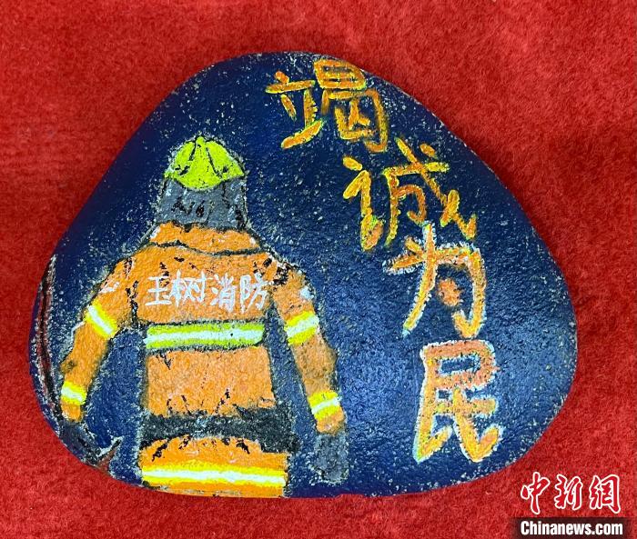 圖為玉樹(shù)消防指戰(zhàn)員創(chuàng)作的石頭畫(huà)作品《逆行在路上》?！O瑞祥 攝