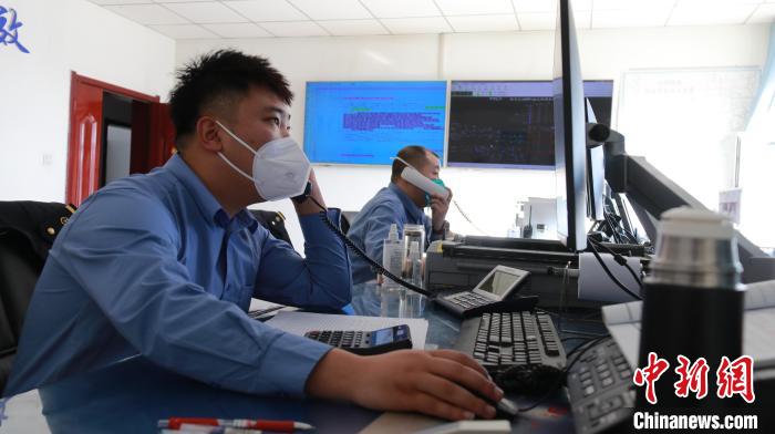 圖為貨運(yùn)調(diào)度人員與外勤工作人員聯(lián)系掌握車輛裝載情況?！±钌?攝