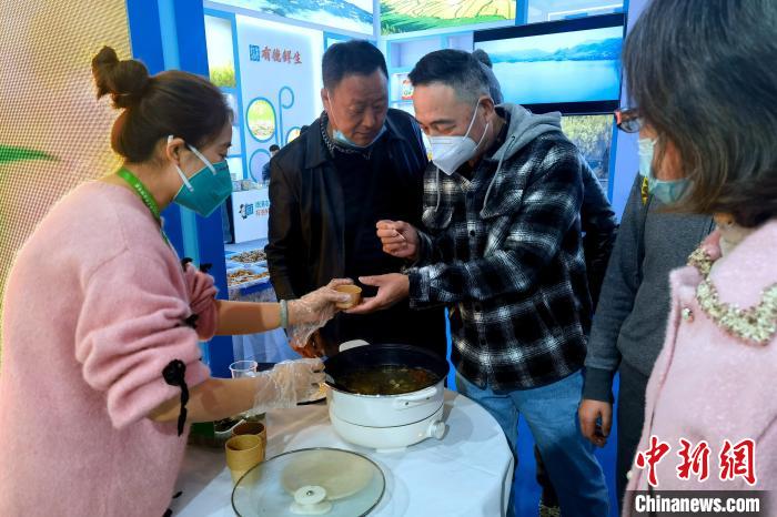 圖為杭州市民品嘗茶卡羊肉?！±铍h 攝