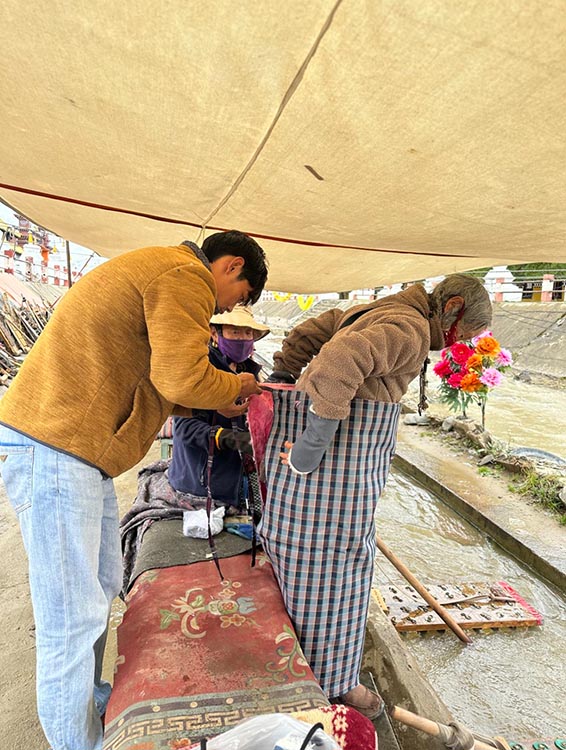 扎西奪爾登為路邊老人送去保暖圍腰。阿壩州文明辦供圖