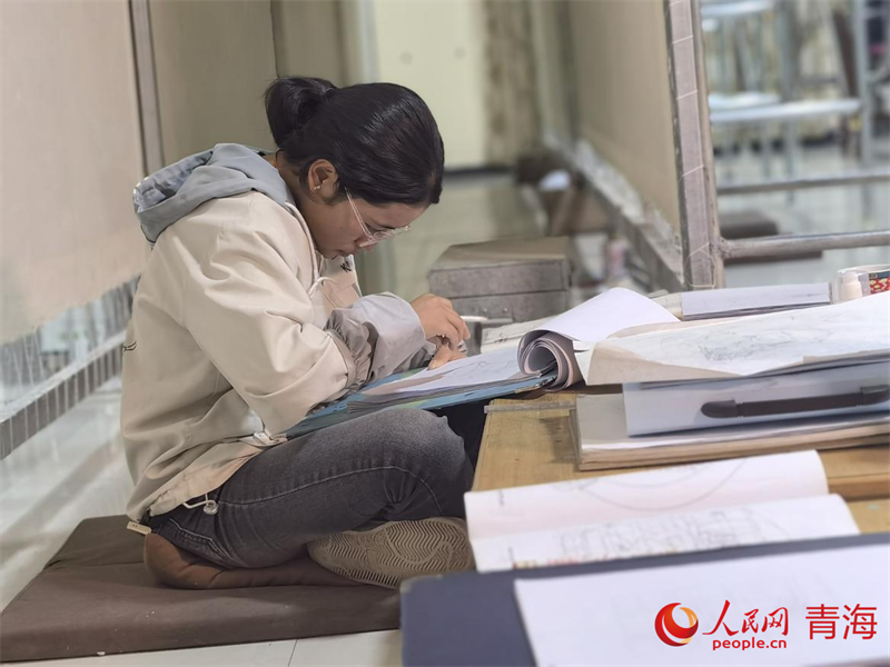 正在學(xué)習(xí)畫底稿的尕讓旺姆。人民網(wǎng) 陳明菊攝